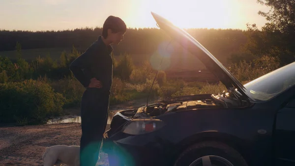 Žena při západu slunce při pohledu na motor. — Stock fotografie