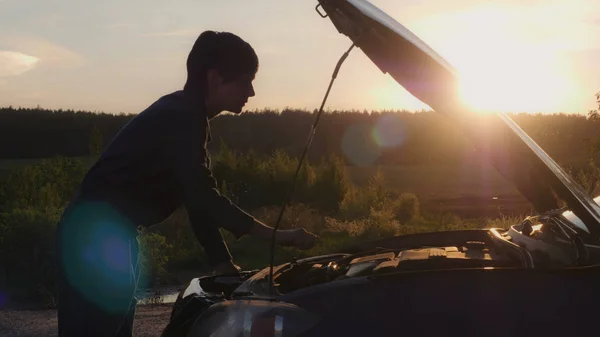 Žena při západu slunce při pohledu na motor. — Stock fotografie