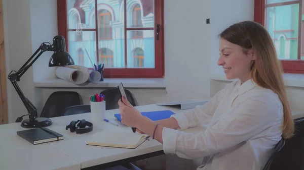 Mujer sosteniendo tableta sonriendo y saludando cliente . — Foto de Stock