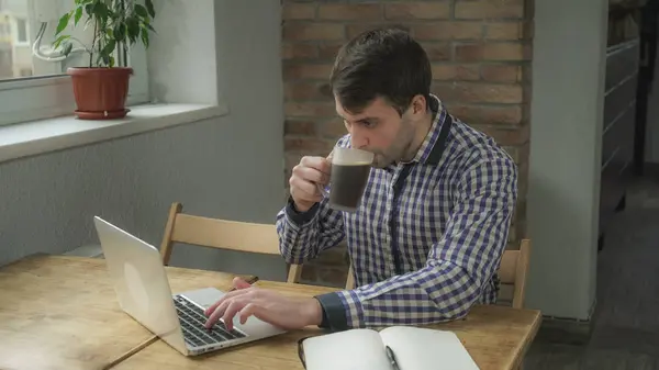 Man concentrated work at the computer and drinking coffee. — Stock Photo, Image