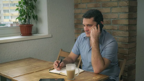 Привабливий дорослий чоловік відпочиває в кафе і розмовляє по телефону . — стокове фото
