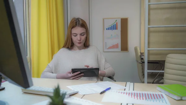 Vrouw met tablet zitten in het kantoor — Stockfoto