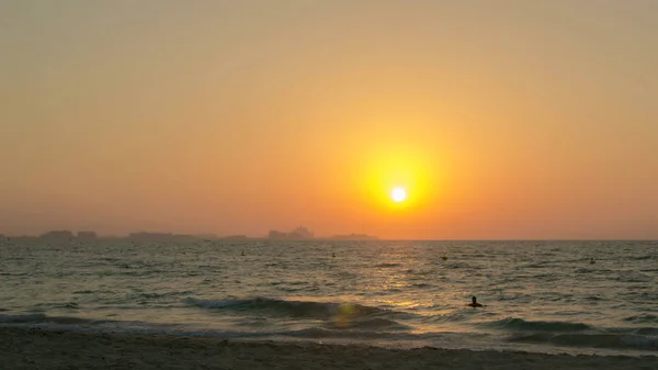 Солнце заходит за горизонт на пляже — стоковое фото
