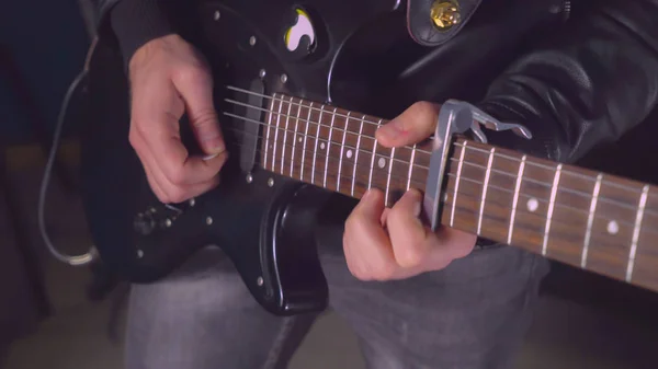 Guitarist with black musical instrument on the concert or try-ou — Stock Photo, Image