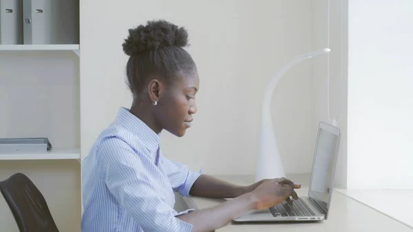 Afroamerikanerin arbeitet am Laptop. — Stockfoto