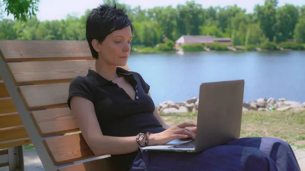 Žena pracuje na notebooku venku. — Stock fotografie