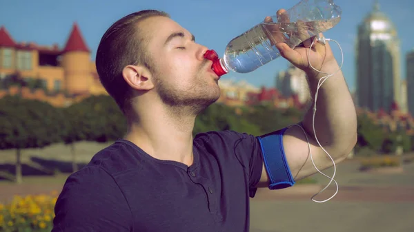 Un homme boit de l'eau après l'entraînement . — Photo