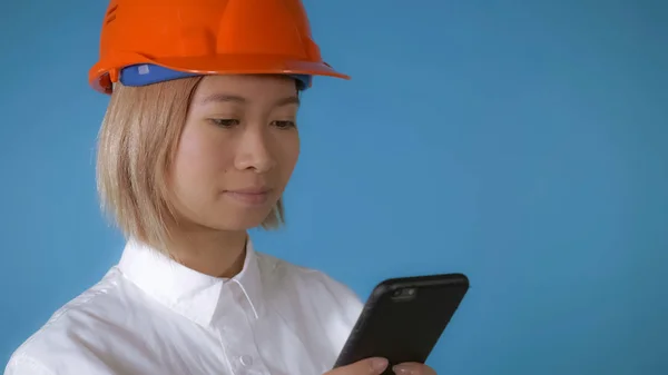 Beautiful worker in uniform texting on mobile — Stock Photo, Image