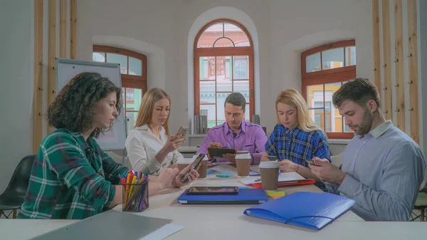 Equipo diverso que utiliza la aplicación en el teléfono móvil . — Foto de Stock