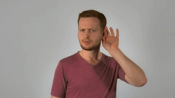 Ginger male shows sign listens attentively — Stock Photo, Image