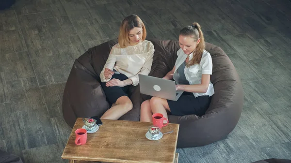 Twee mooie blondjes maken een online aankoop, een bedrijf van een credit card, en de tweede maakt een aankoop met laptop. — Stockfoto