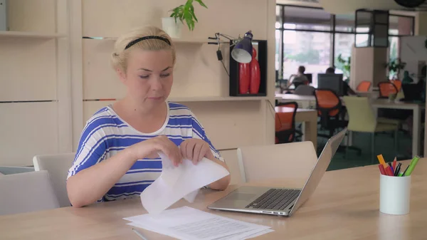 Blonde volwassen werknemer schriftelijk verslag en scheur papierdocumenten — Stockfoto