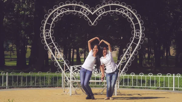 Irmãs se divertem mostrando sinal de amor . — Fotografia de Stock