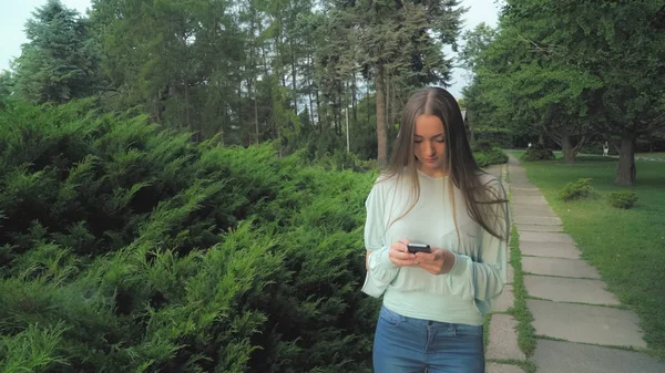 Uma garota de blusa vai na pista no parque e se torna a mensagem . — Fotografia de Stock