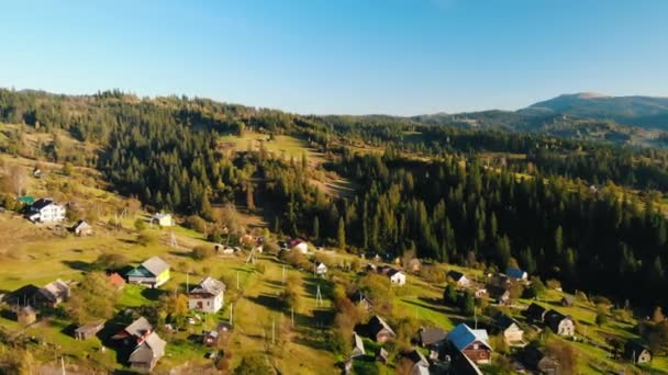 Voando para a frente sobre pequenas casas nas terras altas — Vídeo de Stock