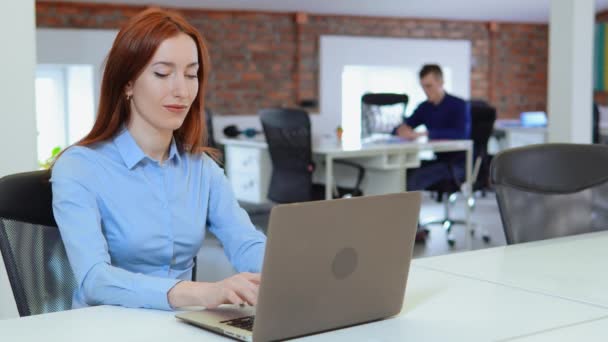 Mujer de negocios con el pelo rojo posando trabajando en PC — Vídeos de Stock