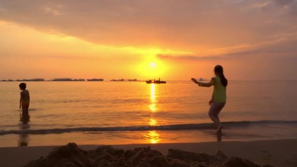 Silhouettes d'enfants jouant dans les vagues de l'océan — Video