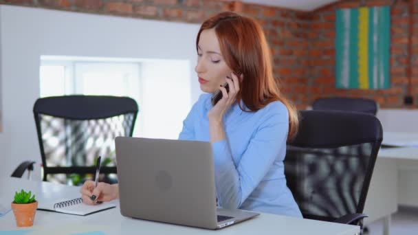 Mulher de negócios com telefone celular, computador portátil no trabalho no escritório — Vídeo de Stock