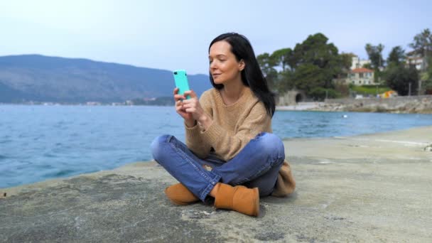 Брюнетка использовать мобильный в средиземноморском городе — стоковое видео