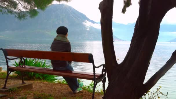 Tillbaka syn på kvinnan som sitter vid havet på toppen av klippan, Montenegro. — Stockvideo