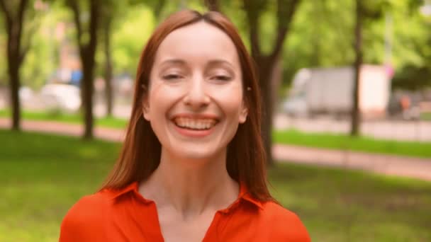 Рыжая женщина широко улыбается природе летом — стоковое видео