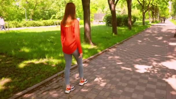 Schöne junge Frau entspannt sich im Sommerpark — Stockvideo