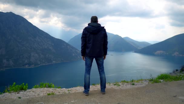 L'uomo in piedi sulla vetta della montagna gode di un paesaggio mozzafiato — Video Stock