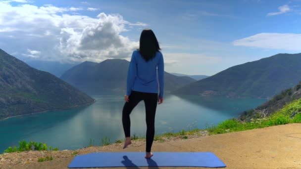 Schönes Mädchen macht Yoga auf Klippe — Stockvideo