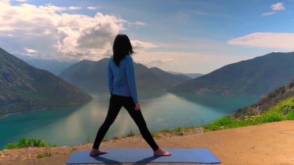 Taut žena cvičila Jómu cvičení na vrcholku hory — Stock video