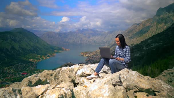 Chica pasa tiempo en la montaña con el ordenador portátil — Vídeo de stock