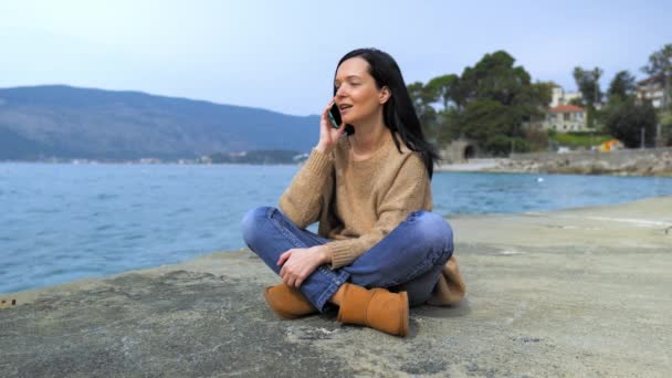 Jeune femme séduisante assise sur le pont — Video