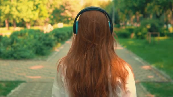 Вид ззаду жінка слухає музику на відкритому повітрі — стокове відео