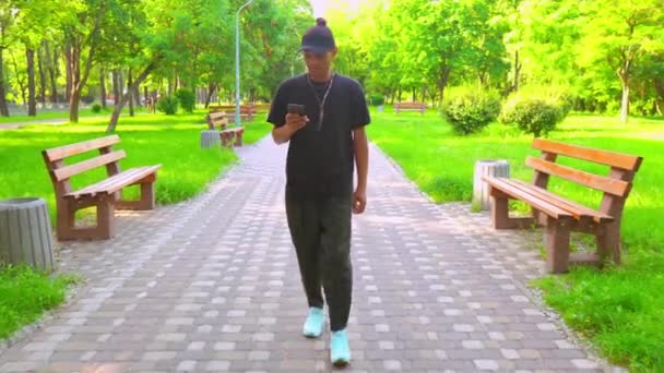 Mann trägt trendige Klamotten Nachrichten auf dem Handy — Stockvideo