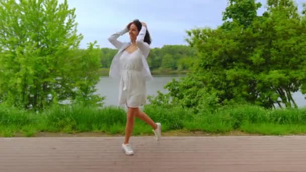 Mujer joven escuchando música al aire libre — Vídeos de Stock