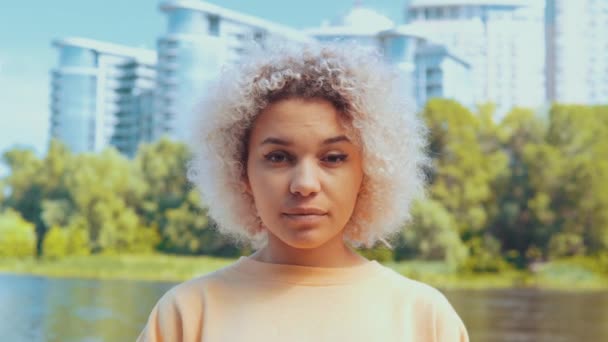 Κοντινό πρόσωπο νεαρή γυναίκα με ξανθά μαλλιά σε εξωτερικούς χώρους — Αρχείο Βίντεο
