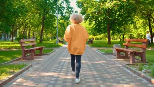 Blond kvinna med lockigt hår promenad på gatan — Stockvideo