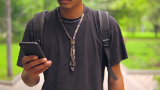 認識できない男は、スマートフォンを使用して屋外散歩 — ストック動画