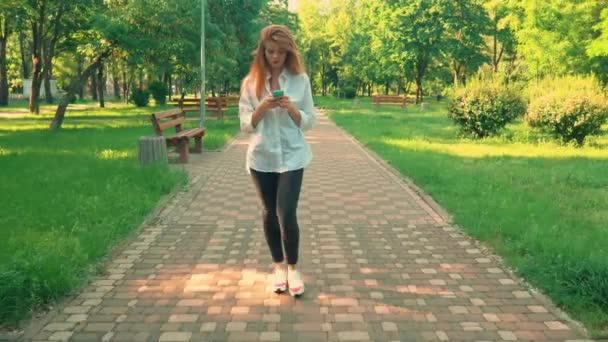 Millennials walking on the street using smartphone — стоковое видео