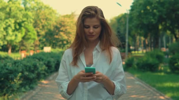 Крупним планом молода жінка ходить в чаті по телефону — стокове відео
