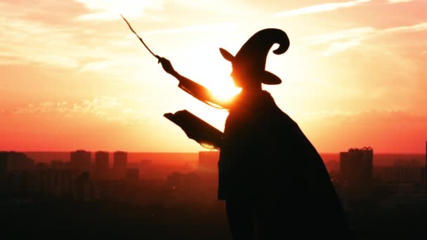 Девушка в костюме ведьмы книга заклинаний городской пейзаж замедленной съемки восход солнца — стоковое видео
