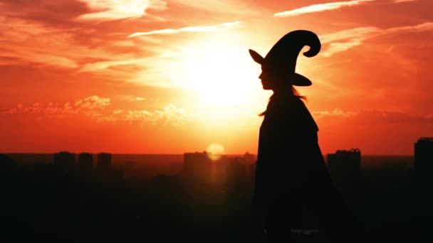 Menina vista lateral em um traje de bruxa oferece conceito de Halloween maçã — Vídeo de Stock