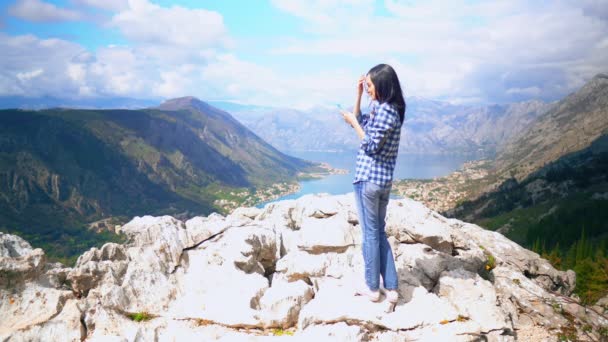 Lány használ smartphone gépelési masszázs hegyi táj nyáron — Stock videók