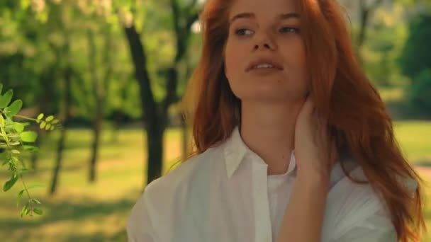 Retrato mujer joven jugar con el pelo rojo posando al aire libre — Vídeo de stock