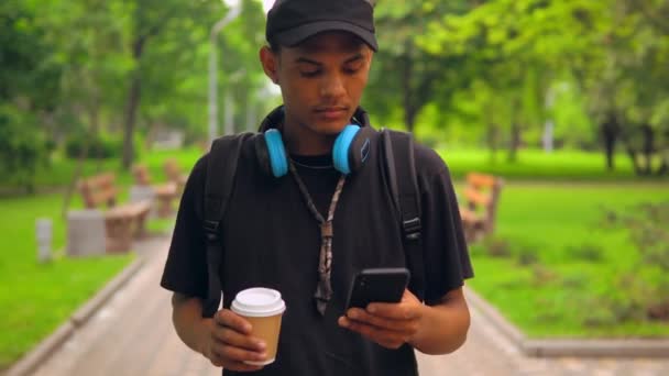 Портрет смешанной расы парень пьет кофе смс сообщение — стоковое видео