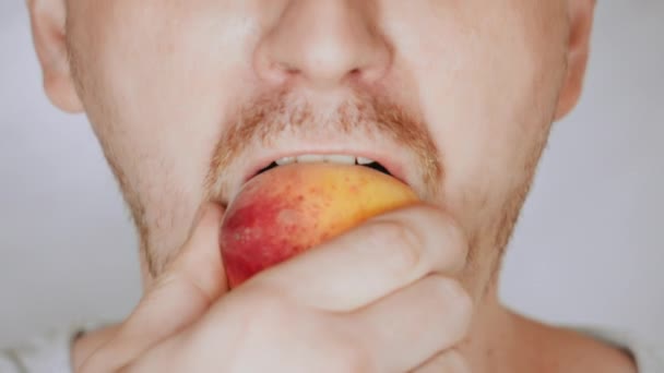 Close up face fair man eat apricot — Stock Video