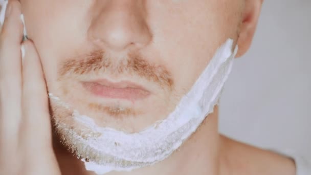Close up cara justo homem usando a espuma de barbear — Vídeo de Stock