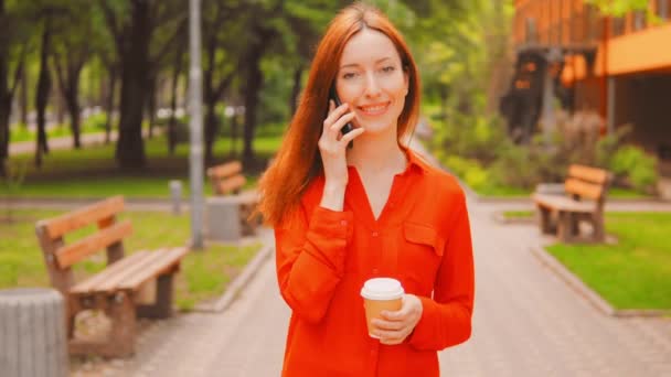 Женщина разговаривает по телефону во время пробежки утром — стоковое видео