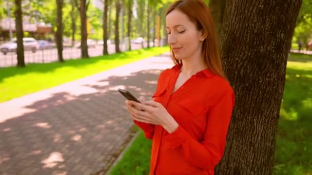 Mooie zakenvrouw met behulp van smartphone in stad — Stockvideo