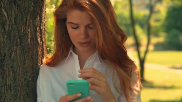 Retrato mujer adulta usando teléfono inteligente en el parque — Vídeos de Stock