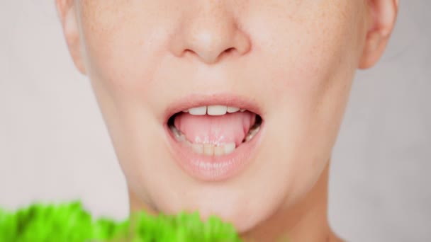 Close-up gezicht jonge vrouw eten bladgroente — Stockvideo